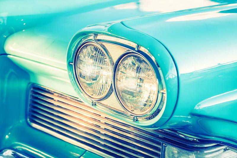 Front eines türkisfarbenen Oldtimers mit Doppelscheinwerfern